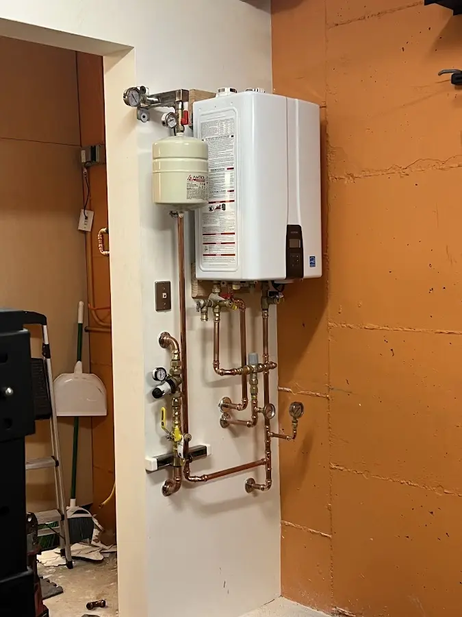Plumbing technician inspecting water heater connections in Haines City